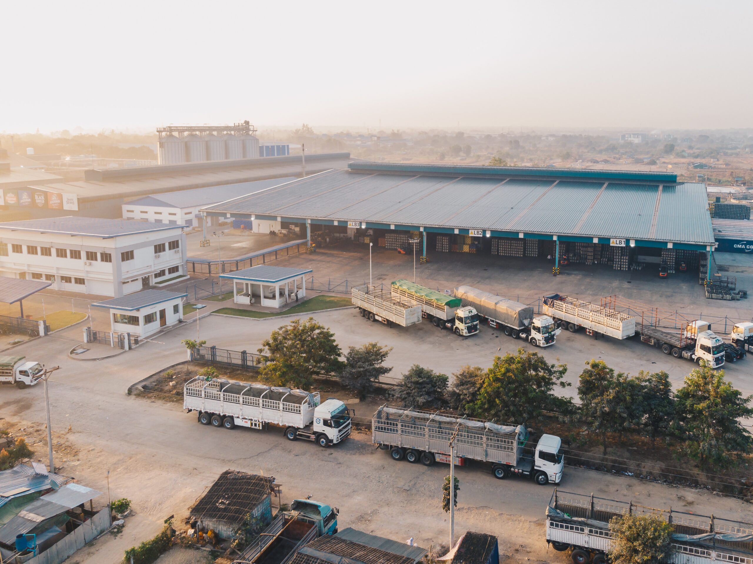 aerial view factory trucks parked near warehouse daytime scaled