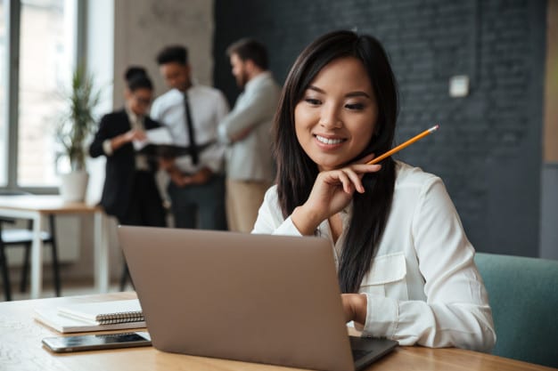 cheerful young asian businesswoman using laptop 171337 724