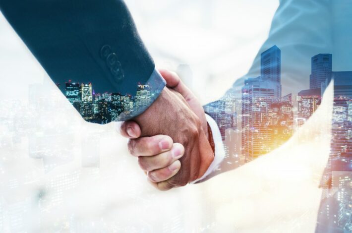 welcome double exposure business man partner handshake scaled 1